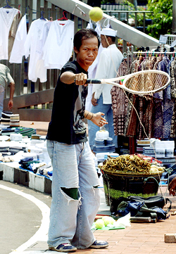 A street vendor plays his merchandise as he waits for customers in Jakarta on Friday