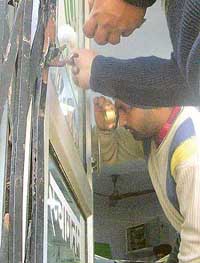 Fingerprint experts examine the robbery site at the Oriental Bank branch, Government College, Mohali, on Friday