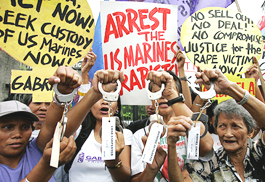 Filipinos hold up handcuffs during a protest demanding the arrest of four US Marines charged with raping a Filipino woman