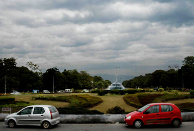 Hovering dark clouds above and a fountain with water gushing out below make the environment look greener and cleaner as cars in contrasting colours zip past the Matka Chowk in Chandigarh on Tuesday