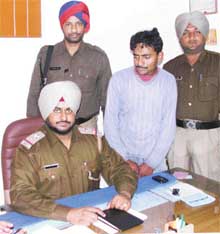 SHO G. S. Bains poses with the alleged extortionist, Raman Kumar, at the Salem Tabri police station