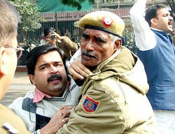 A BJP activist scuffles with the cop during a protest against the Congress party in New Delhi on Tuesday.