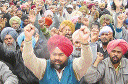 Members of the Punjab Field and Workshop Workers Union hold protest in front of the office of PUDA in Mohali on Wednesday.