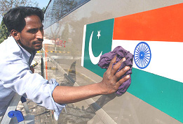 A worker washes the Indo-Pak National Flags painted on the side of a bus used for the Amritsar-Lahore-Amritsar bus service in Amritsar on Monday. The first bus making the Amritsar-Lahore-Amritsar trip is scheduled to depart on Tuesday.
