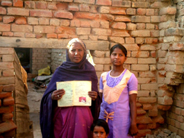 Sarla and her daughter Manju, who are living in abject poverty, show a green ration card (meant for well-to-do families) issued to them in front of their dilapidated house in Hisar on Friday.