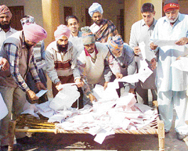 Villagers try to trace out their electricity bills at Sekhpura village.