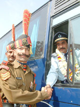 A BSF jawan shakes hands with Mr Nasir Shah, driver of the Nankana Sahib - Amritsar bus, at the Wagah joint check-post