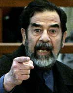 Former Iraqi President Saddam Hussein gestures in court inside the heavily fortified Green Zone in Baghdad