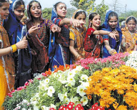 Schoolgirls in colourful dresses take delight in the beautiful flowers on show after the inauguration of the 19th Garden Tourism Festival at the Garden of Five Senses in the Capital on Friday. 