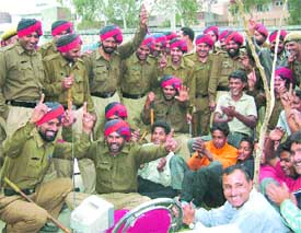 Policemen along with some local residents engrossed in the TV telecast of the India-Pakistan One Day International match in Jalandhar on Sunday