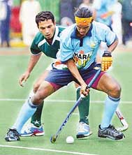Indias Parbodh Tirkey and Adnan Maqsood of Pakistan fight for the ball during the fourth match of the Indo-Pak hockey series in Lahore on Wednesday.