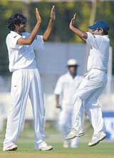 Board Presidents XI bowler Munaf Patel and team-mate Pragyan Ojha celebrate the dismissal of Mathew Hoggard of England on the first day of a three-day practise match in Vadodara on Thursday