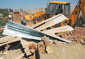 A JCB machine demolishes illegal structures at Kharag Mangoli, Panchkula, on Friday. 