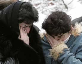 Women grieve outside a morgue