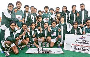Members of the Pakistan team pose with the winners trophy after clinching the series against India 3-1 at the Army Hockey Stadium in Rawalpindi on Sunday.