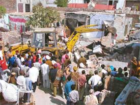 A bulldozer removes encroachments in Pavitter Nagar