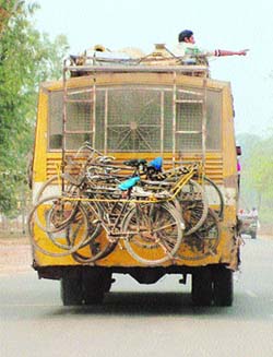 Bicycles travel by a local bus in Amritsar. 