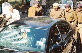 Policemen inspect the spot where some cars were smashed at Panjab University in Chandigarh