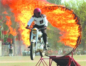 A motorcyclist jumps through a ring of fire during a show to mark the silver jubilee celebrations of the 18 Dogra Regiment in Jalandhar Cantonment on Thursday