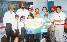 Students of Harkishan school display the cheque presented to the school by Disney Channel in Ludhiana