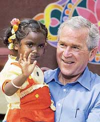 US President George W. Bush holds a girl during a visit to the Acharya N.G. Ranga Agriculture University in Hyderabad on Friday.
