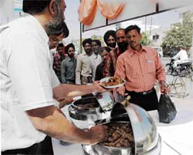 People queue up to buy chicken dishes at a mela at Sarabha Nagar in Ludhiana on Saturday