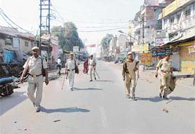 Policemen patrol a street after clashes in Lucknow