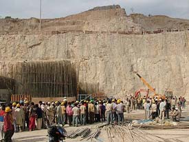 Agitated workers gather at the Kol Dam site where four persons were killed and three injured in an accident 