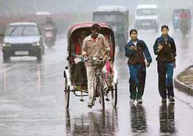 Commuters rush to their destinations during rain in Chandigarh on Friday.