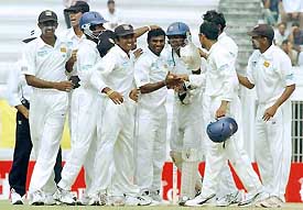 Sri Lankan cricketer Muttiah Muralitharan is congratulated by his team-mates after dismissing Bangladeshi batsman Mohammad Ashraful 