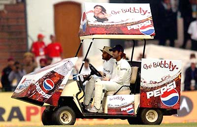 Harbhajan Singh and Mahendra Dhoni drive the drinks trolley after the days play was stopped due to bad light during the second day of the second Test between India and England in Mohali on Friday