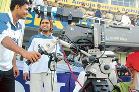 Indian team players Irfan Pathan and Mohinder Singh Dhoni enjoy a view of spectators in the PCA stadium, Mohali, through the Digi super camera during the lunch session on the third day of the second Test match being played between India and England on Saturday