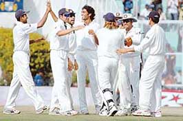 Munaf Patel (centre) celebrates with team-mates after dismissing Englands Alastair Cook on the fourth day of the second Test at the PCA Stadium in Mohali on Sunday.