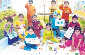 Students of Lovely Lotus play Holi by splashing colours on paper
