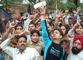 Protesting shopkeepers and residents of the Putlighar area raise slogans against Municipal Corporation at Town Hall in Amritsar on Monday.