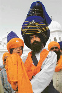A Nihang and his 3-year-old son in their traditional headgear on the first day of Hola Mohalla in Anandpur Sahib on Monday.