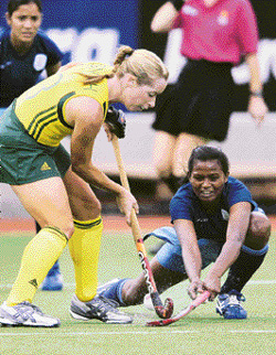 An India player blocks the advance of Karen Smith of Australia in their womens hockey match at the Commonwealth Games in Melbourne on Thursday