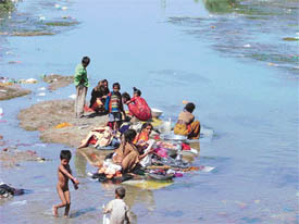  slum dwellers wash clothes in the canal on Saturday