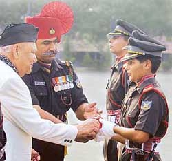 Lt-Gen (retd) S. K. Sinha, Governor of Jammu and Kashmir, presents the gold medal for the best all rounder to Senior Under Officer Neelam Rathee during the 81st passing out parade at the Officers Training Academy in Chennai on Saturday. 