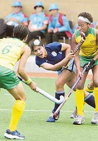 Indian forward Jasjeet Handra flicks the ball past South Africa defender Lenise Marais (left) and midfielder Lesle-Ann George during their womens hockey match in Melbourne on Saturday