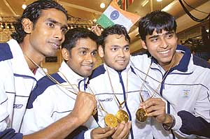 Members of the Indian mens table tennis team rejoice after winning the gold medal at the Commonwealth Games on Monday. India beat Singapore 3-2 in the final.