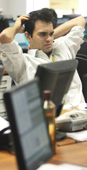 A stock dealer takes a breather during a heavy morning trading session as the share index hit a record high of 11,000 points in 29 trading days in Mumbai on Tuesday