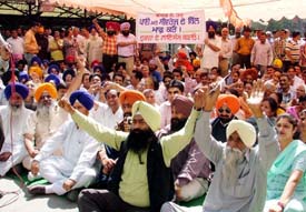 Activists of the SAD and the BJP stage a dharna in front of the Municipal Corporation office in Ludhiana on Wednesday