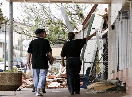 Insurance workers inspect buildings damaged by Cyclone Larry on the main street of Innisfail, about 100 km south of Cairns in northern Queensland