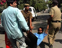 Railway police jawans arrest an agitator during a protest by the Poultry Farm Association at the Chandigarh railway station on Thursday.