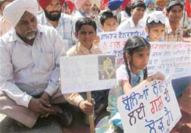 Children with placards at a function at Bhagat Singh Chowk at Ahmedgarh on Thursday
