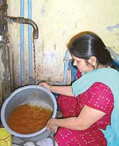 A woman shows contaminated water drawn from a hand pump in Pathankot.