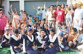 Residents of Palsora village protest in front of the proposed liquor shop on Thursday