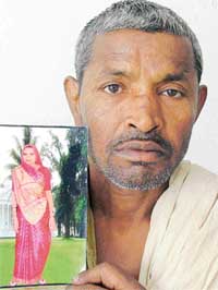 Davinder Mahato with the picture of his wife, Geeta Devi, in Ludhiana on Wednesday