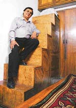 Tapesh Sharma poses on a wood-panelled staircase